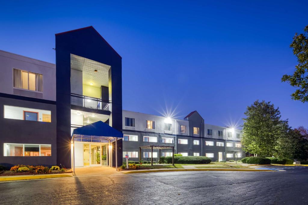 an empty parking lot in front of a building at SureStay Plus Hotel by Best Western Durham Medical Center in Durham