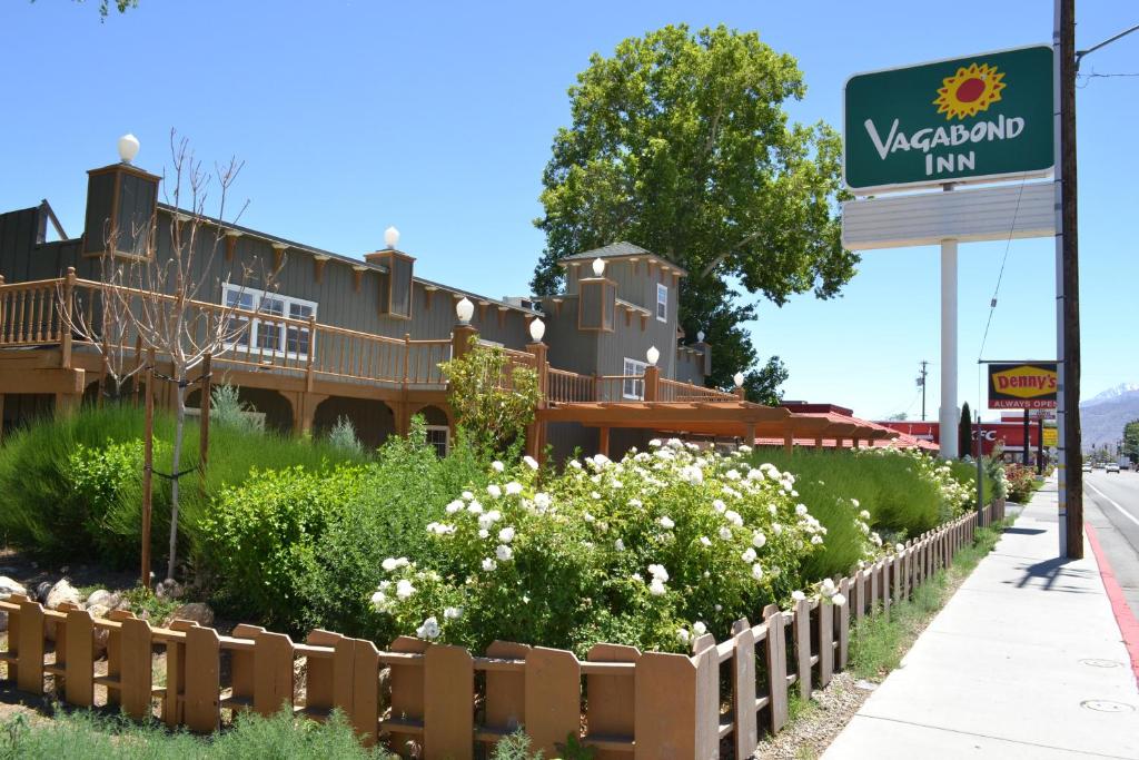 a sign for the westland inn with flowers in front of a fence at Vagabond Inn Bishop in Bishop