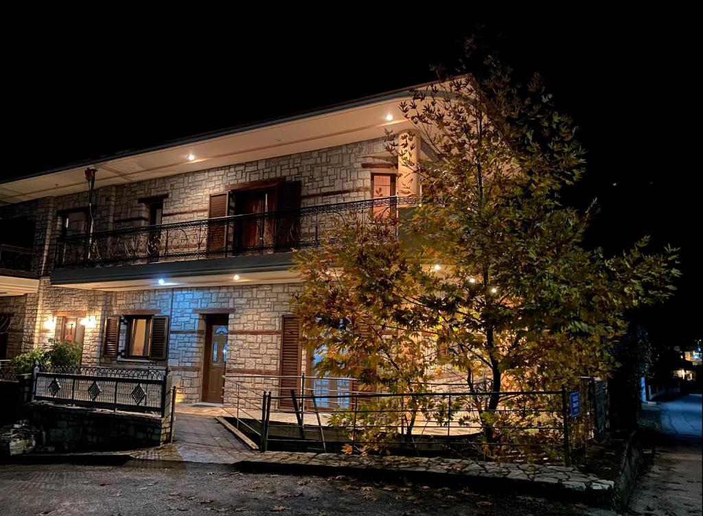 a brick house with a balcony and a tree at Lithotomia Mouzaki in Mouzaki