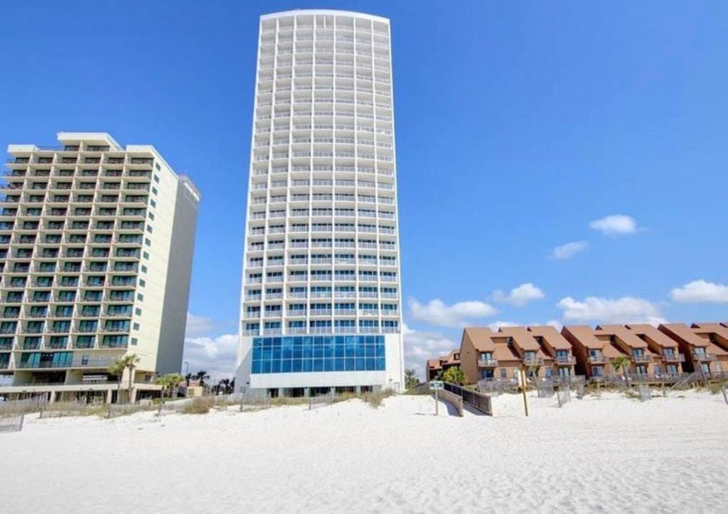 two tall buildings on the beach next to the sand at Island Tower in Gulf Shores