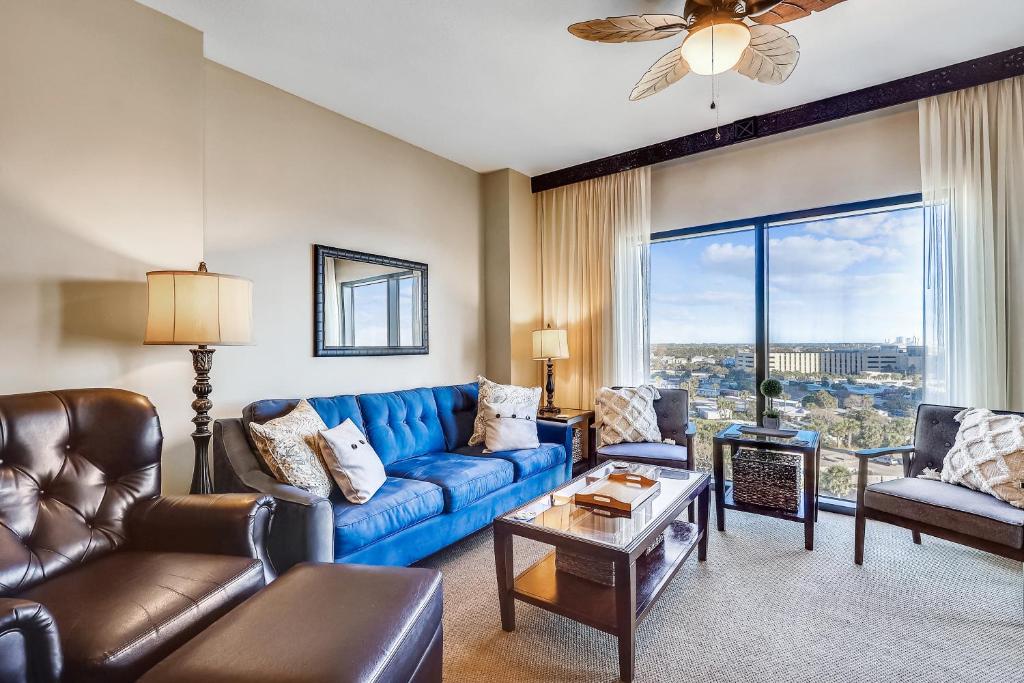 a living room with a blue couch and leather chairs at Origin at Seahaven #831 by Book That Condo in Panama City Beach