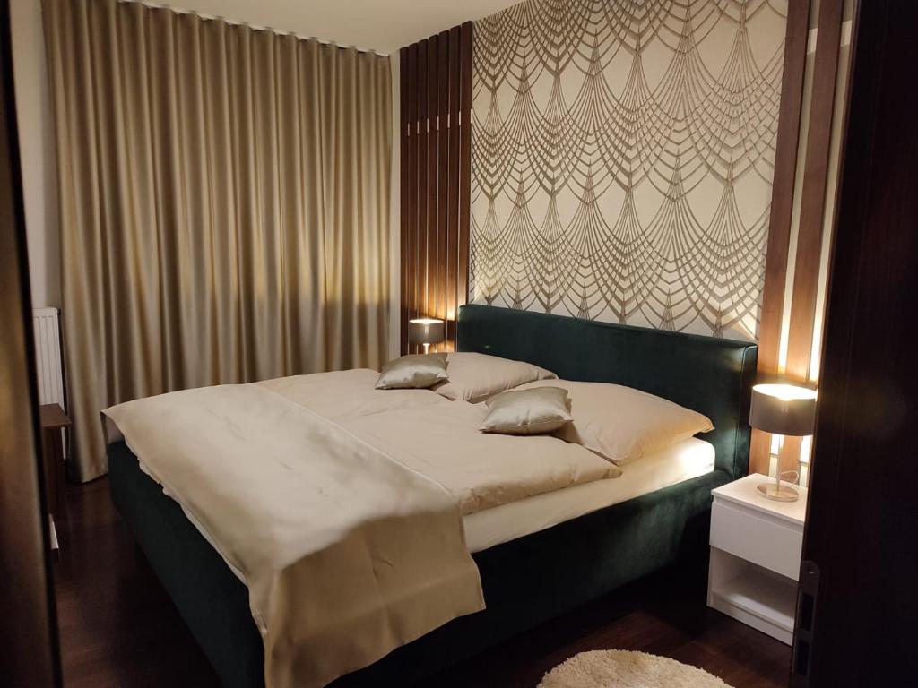 een slaapkamer met een groot bed met een groen hoofdeinde bij Apartment Moser 1303 in Karlsbad