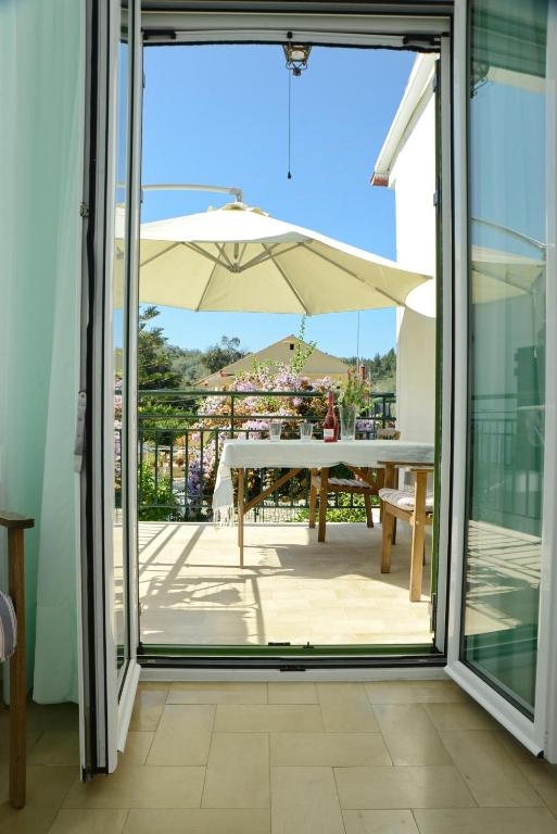a sliding glass door leading to a patio with an umbrella at Penelope - LOGGOS APARTMENTS in Longós