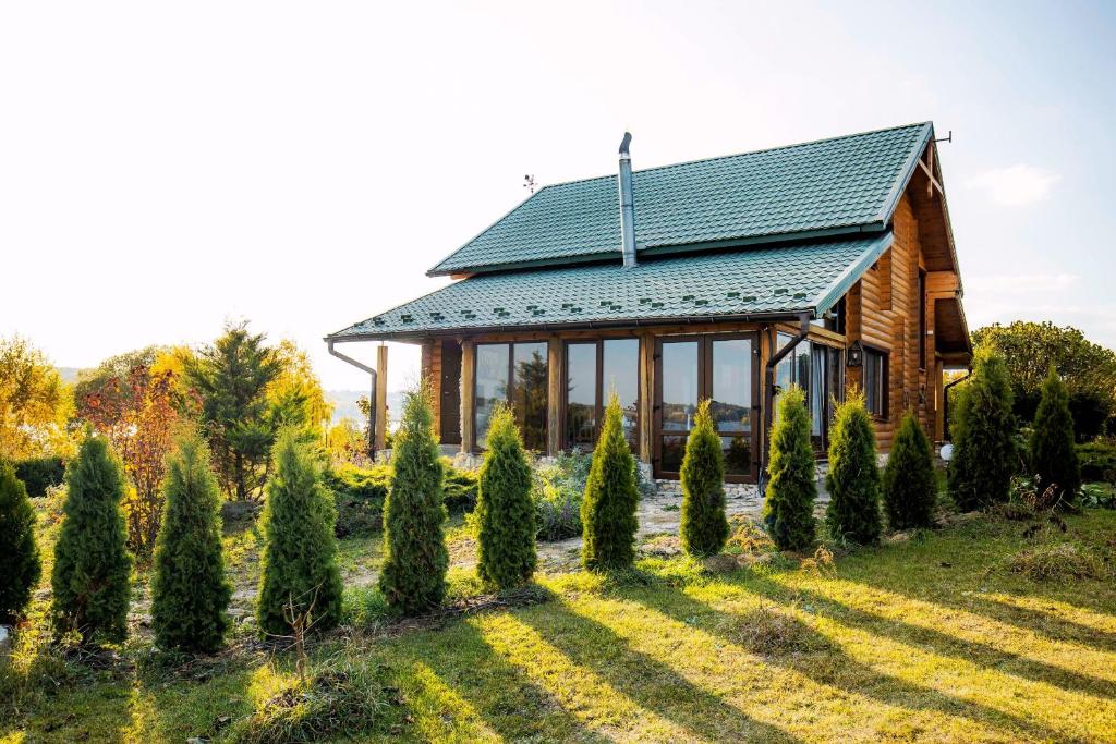 a wooden house with a lot of trees in front of it at Country house Domik v derevne in Markovtsy