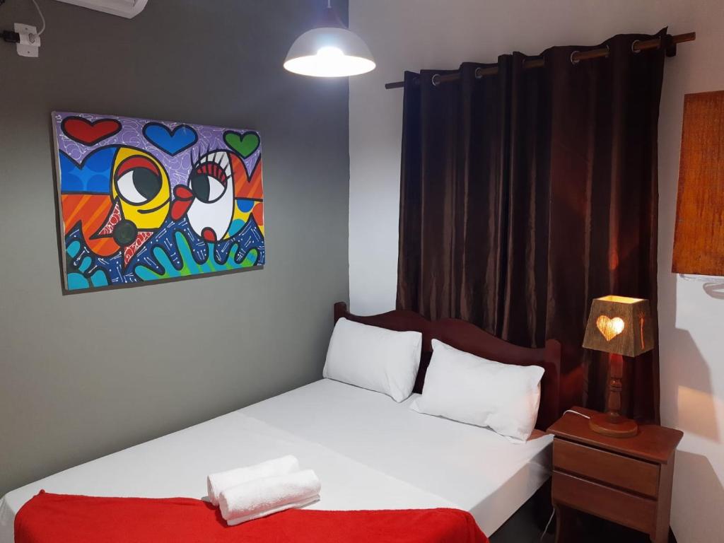 - une chambre avec un lit et une peinture murale dans l'établissement Flat yellow Pipa, à Pipa