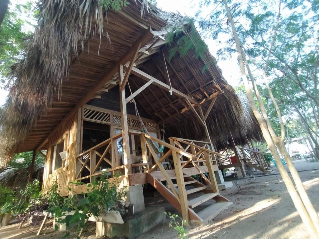 Cabaña pequeña con techo de paja y escalera en Centro Ubuntu en Isla Grande