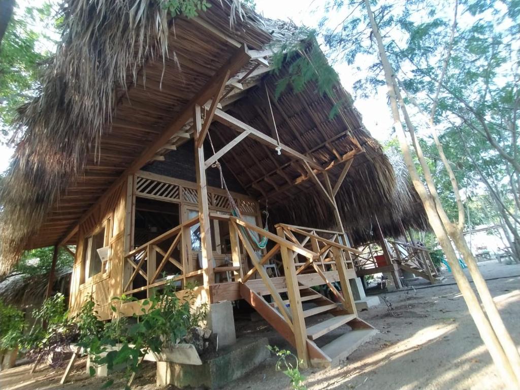 Cabaña pequeña con techo de paja y escalera en Centro Ubuntu, en Isla Grande