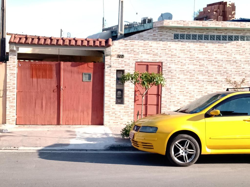 un coche amarillo estacionado frente a un edificio en Kitnet de Inês, en Itanhaém