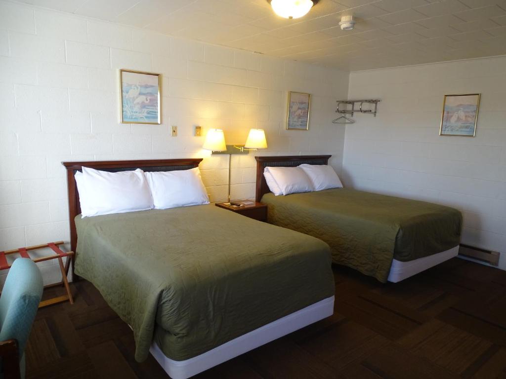 a hotel room with two beds and two lamps at PRAIRIE WINDs MOTEL CARTHAGE 