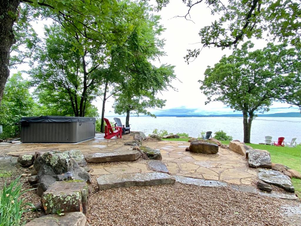 a backyard with a fire pit and a large body of water at Jewell of Eufaula! Lake view, hot tub, and firepit! in Canadian