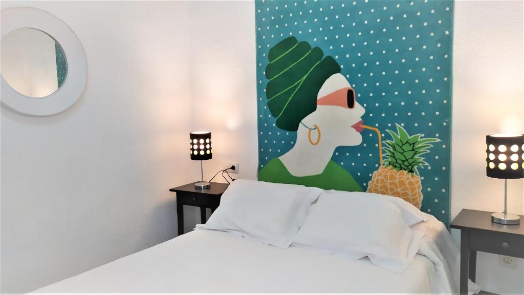 a bedroom with a bed with a painting of a woman at Apartamento Exterior en PARQUE DEL RETIRO- IBIZA DC in Madrid