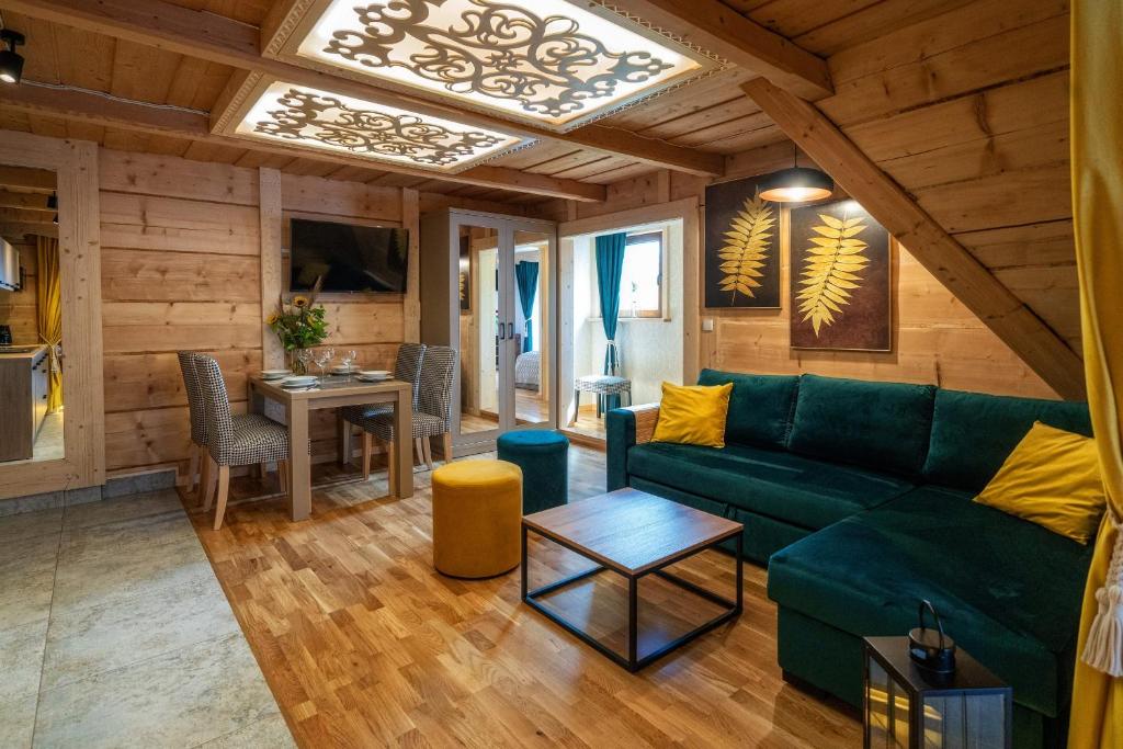 een woonkamer met een groene bank en een tafel bij Chałpa u Zbójnika in Zakopane