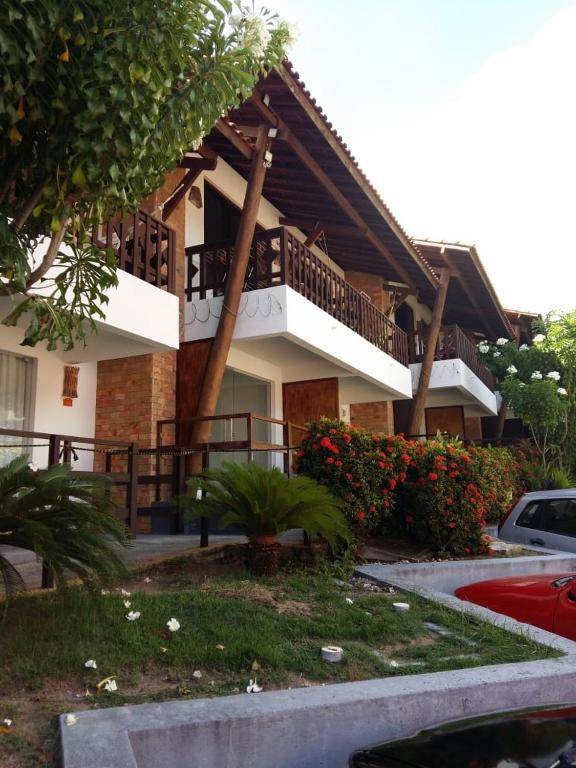 a house with a balcony on the side of it at Sol da Pipa Flat Condominio La Piazzeta in Pipa