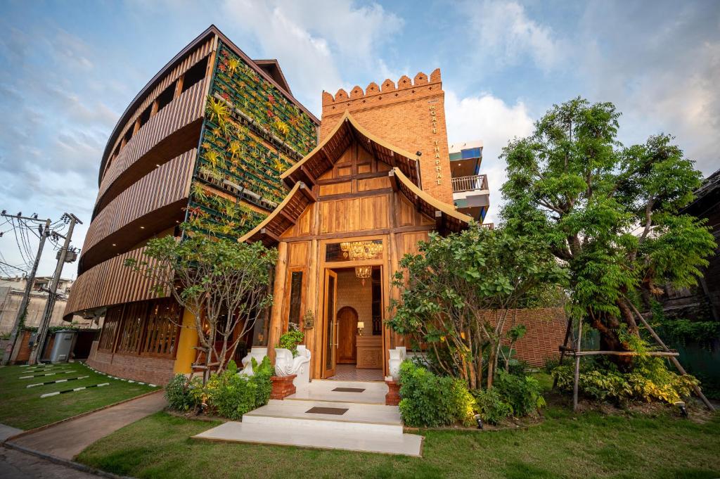 una pequeña casa con un edificio de ladrillo en At Gate Thaphae Hotel, en Chiang Mai
