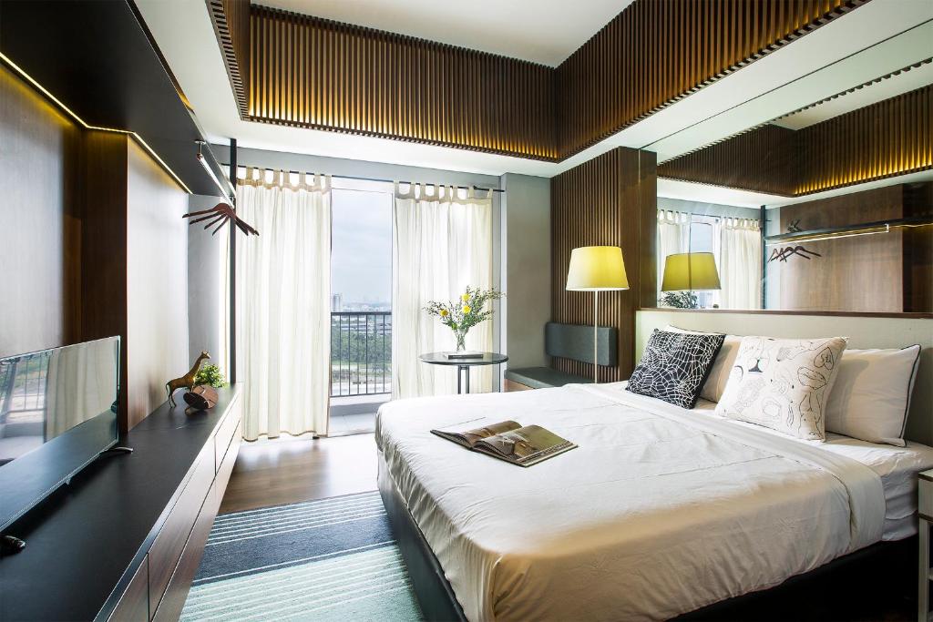 a bedroom with a large bed and a large window at Futura Studio-Modern Apartment near CBD BSD in Serpong