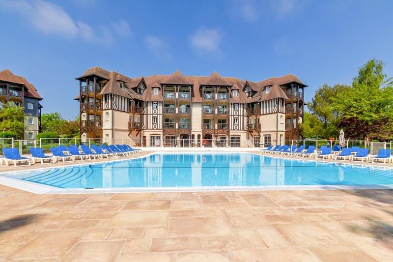 une grande piscine avec des chaises et un bâtiment dans l'établissement 