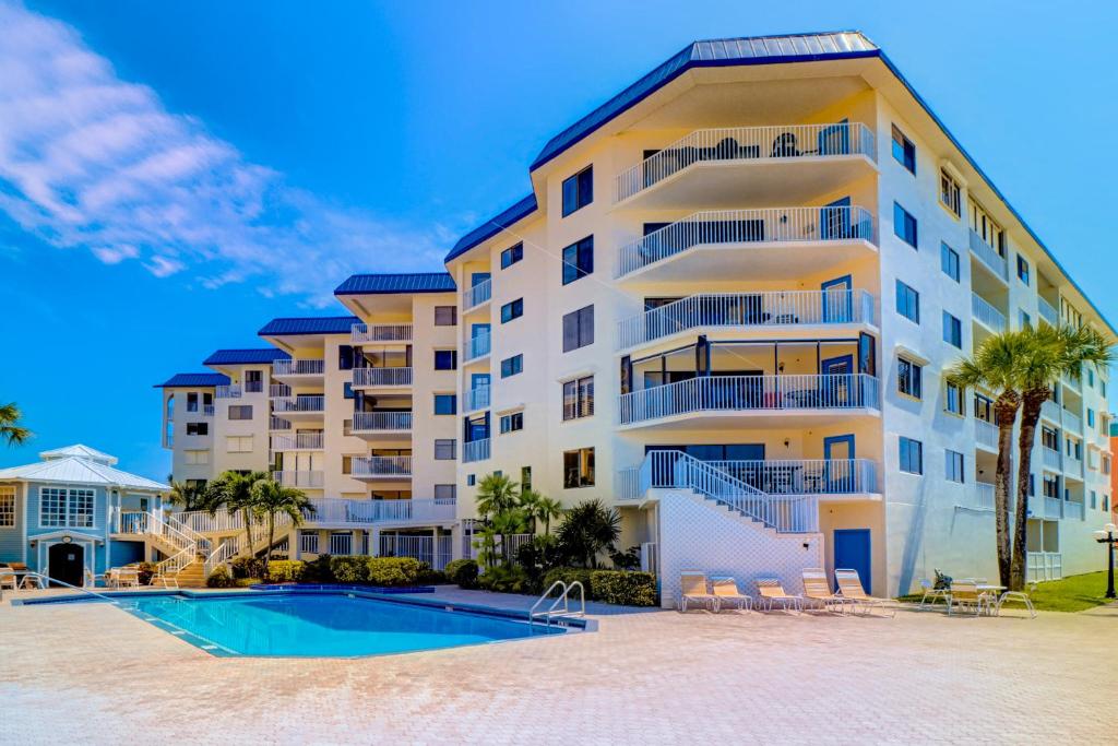 a large apartment building with a swimming pool at Beach Palms in Clearwater Beach