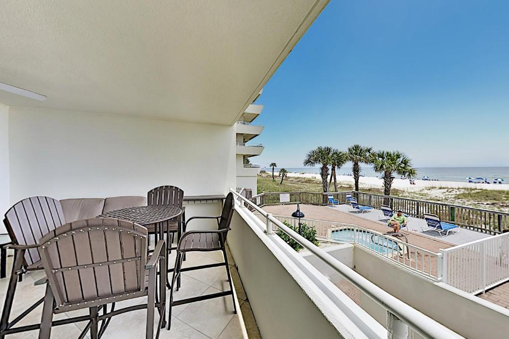 a balcony with chairs and a table and a view of the beach at SeaSpray East E0122 in Perdido Key