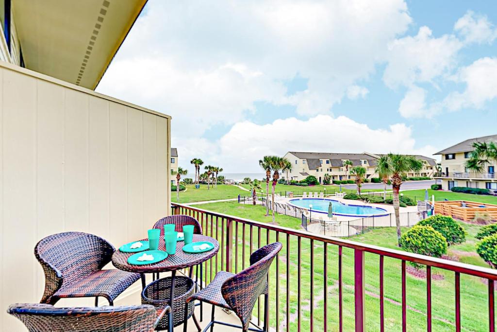 balkon ze stołem i krzesłami oraz basenem w obiekcie Summerhouse Condo w mieście St. Augustine