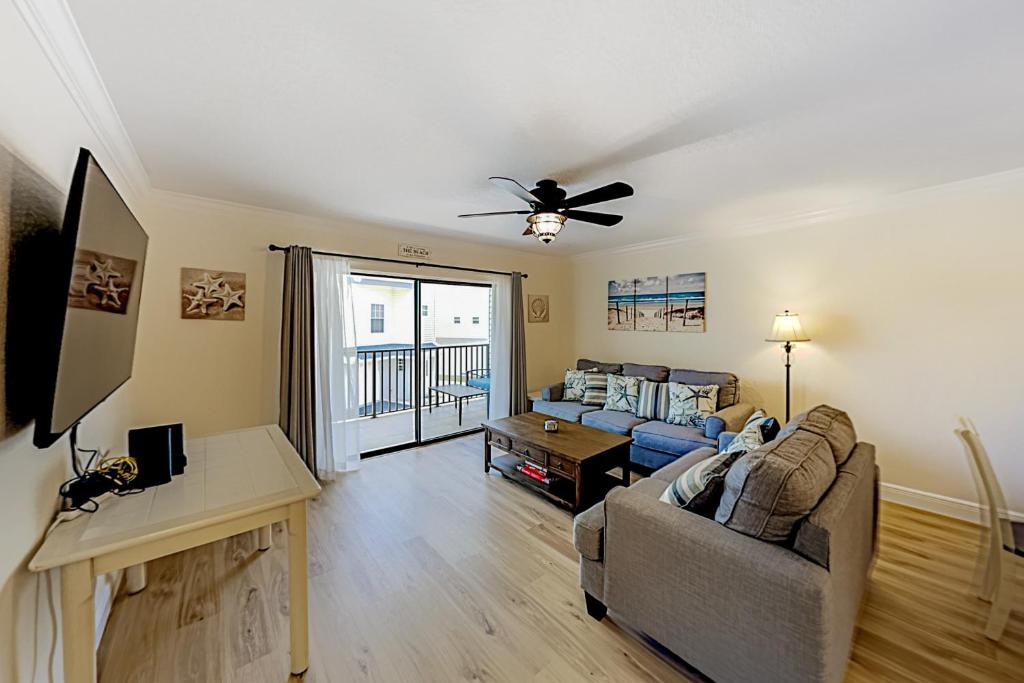 a living room with a couch and a ceiling fan at Bay View Villas #118 in Clearwater Beach