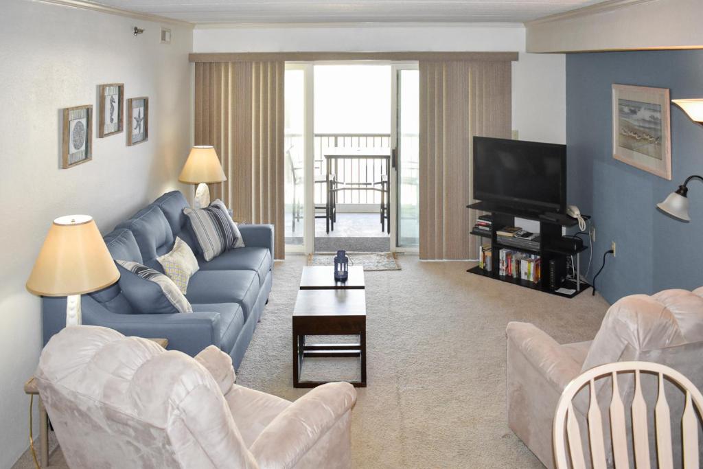 a living room with a couch and a tv at Sandpiper Dunes II in Ocean City