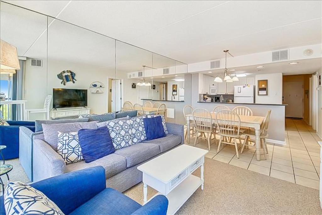 een woonkamer met een blauwe bank en een tafel bij Sea Watch Condos VI in Ocean City