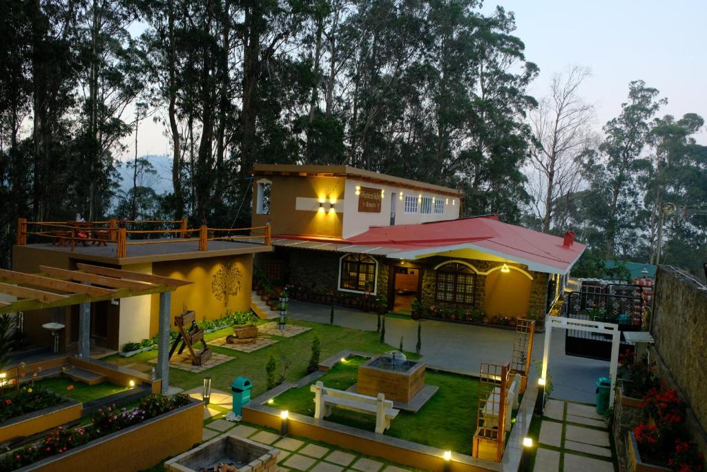 een huis met een patio en een achtertuin met verlichting bij Western Valley Home stay in Kodaikānāl