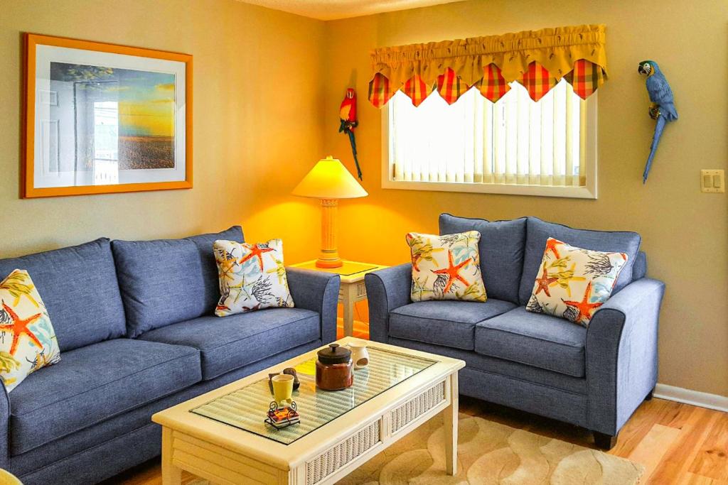 ein Wohnzimmer mit 2 blauen Sofas und einem Couchtisch in der Unterkunft Siesta Villa in Ocean City