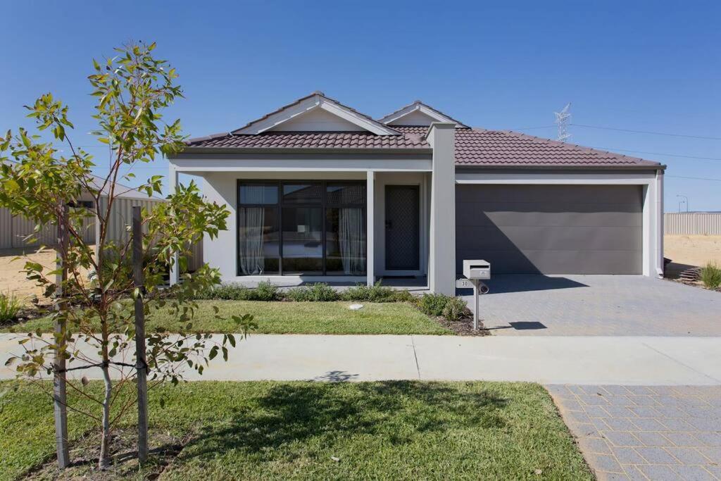 uma casa com garagem e uma árvore em The Kingsley’s Place - EXECUTIVE ESCAPES em Perth