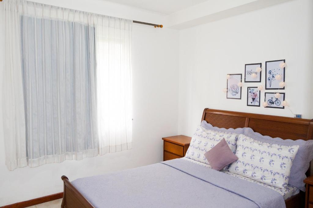 1 dormitorio con cama y ventana en Apartamento aconchegante en Petrópolis