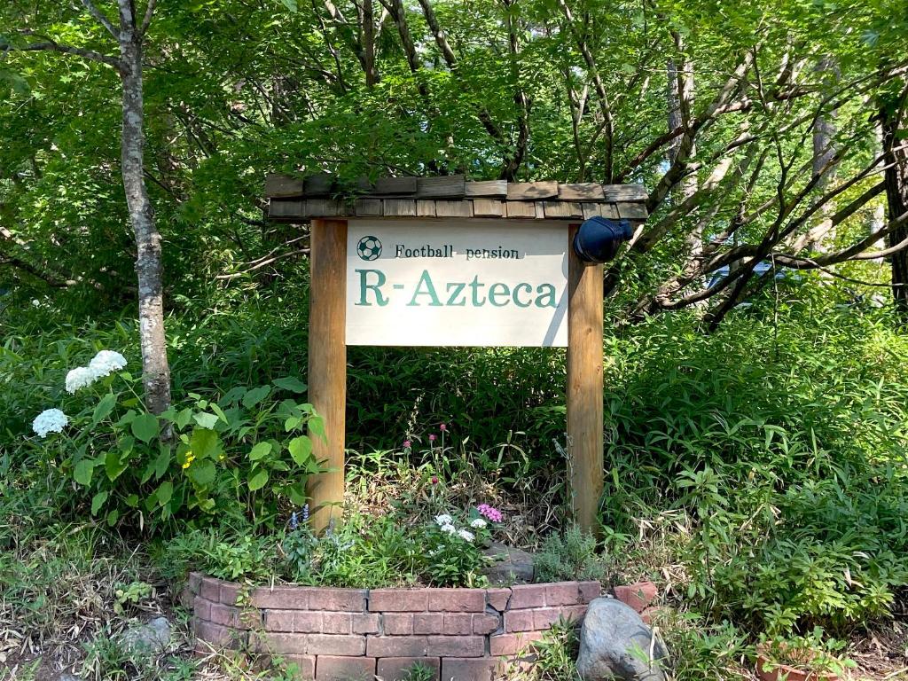 un panneau qui dit razaaza dans un jardin dans l'établissement Pension Razteca, à Hakuba