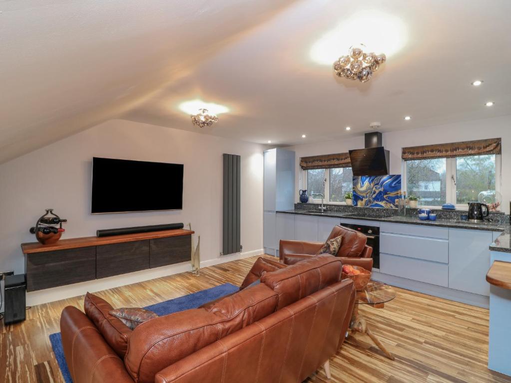 a living room with a couch and a flat screen tv at Orchard View Lodge in Exeter