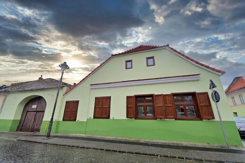 een wit en groen huis met houten deuren bij FLH - Limette Home in Sibiu