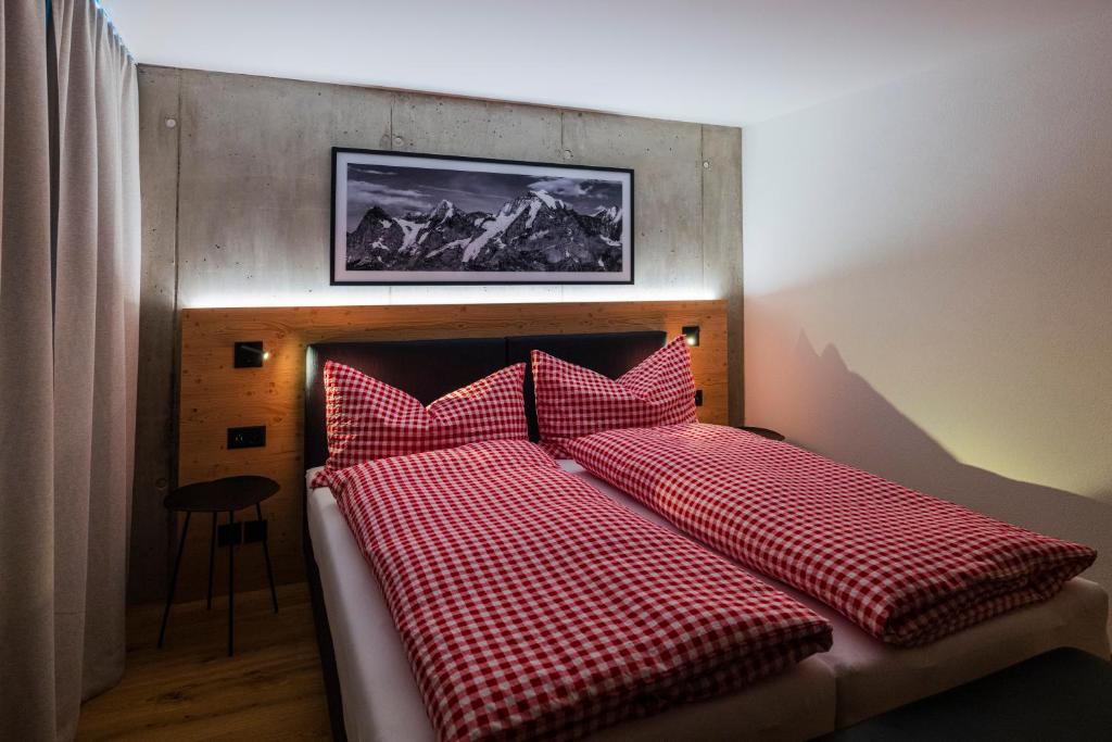 un letto con cuscini a scacchi rossi e bianchi di Chalet Raufthubel a Mürren