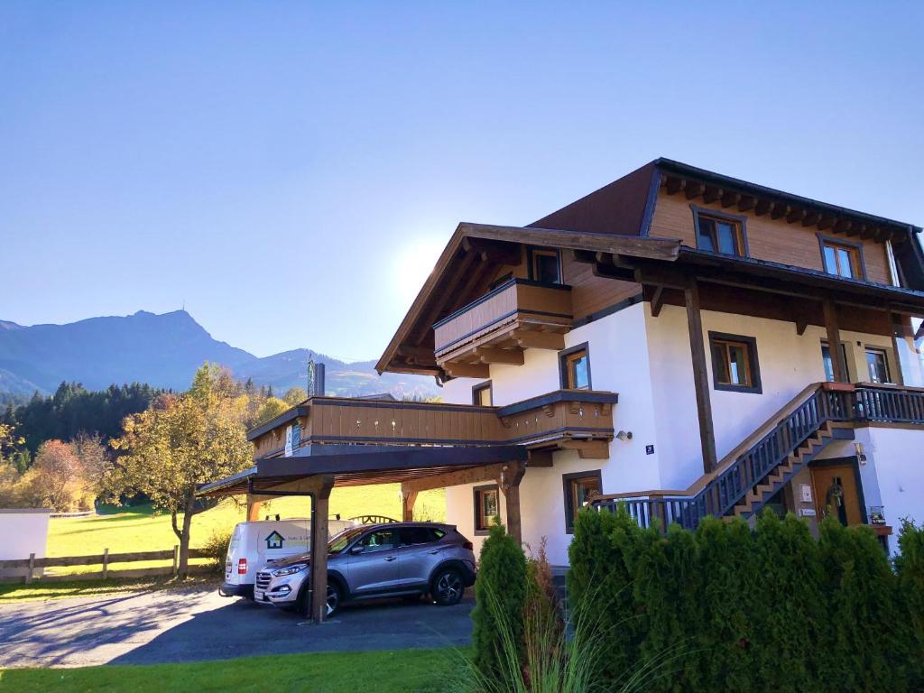 ein Haus mit einem davor geparkt in der Unterkunft Ferienwohnungen Pletzenauer in Sankt Johann in Tirol