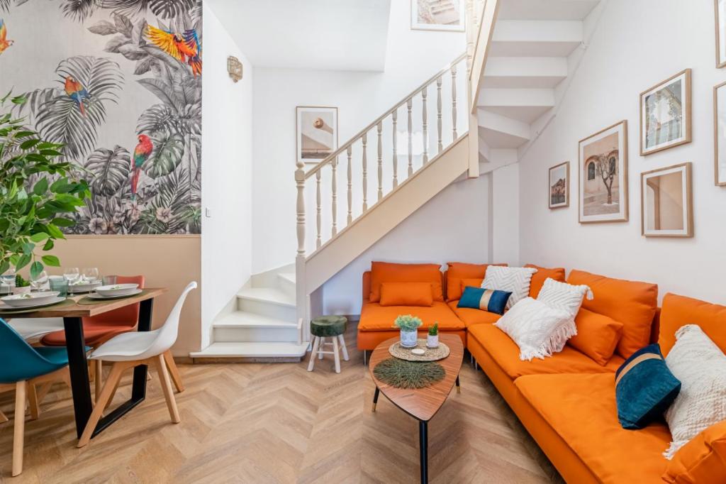 - un salon avec un canapé orange et une table dans l'établissement La ColocXL - Magnifique duplex 110 m² - 5 chambres + parking, à La Ciotat