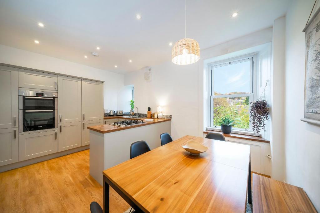 een keuken met een houten tafel en een eetkamer bij Regal Residence in Broughty Ferry