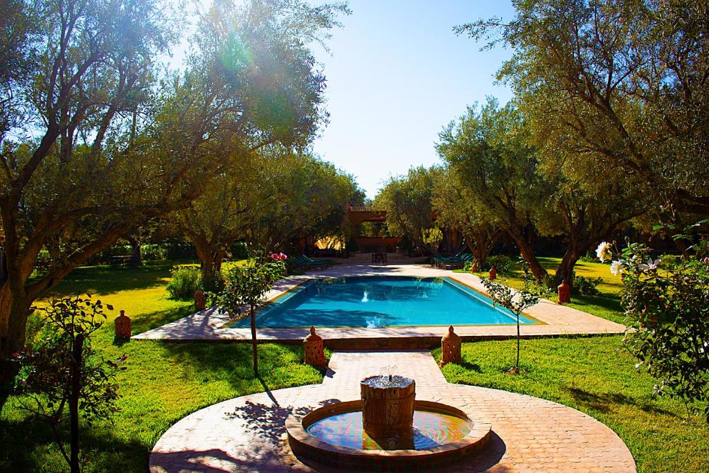a swimming pool in a yard with a fountain at GreenLife Marrakech in Marrakech