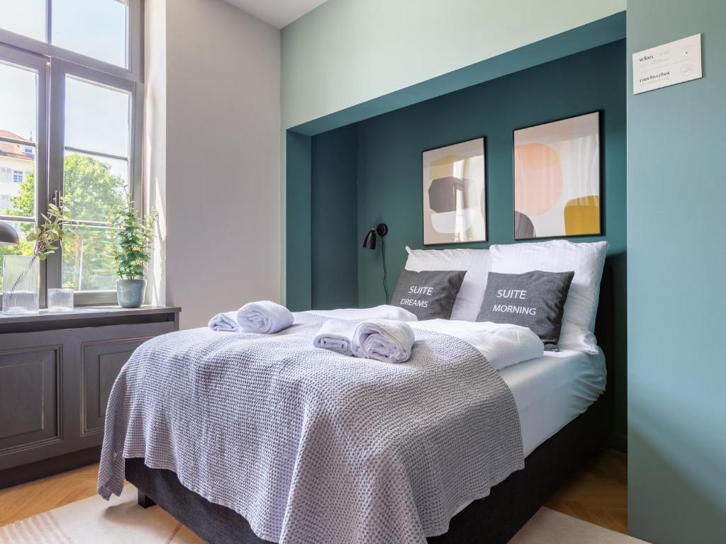 um quarto com uma cama com uma parede em tons de azul em limehome Rottenburg am Neckar Poststraße em Rottenburg