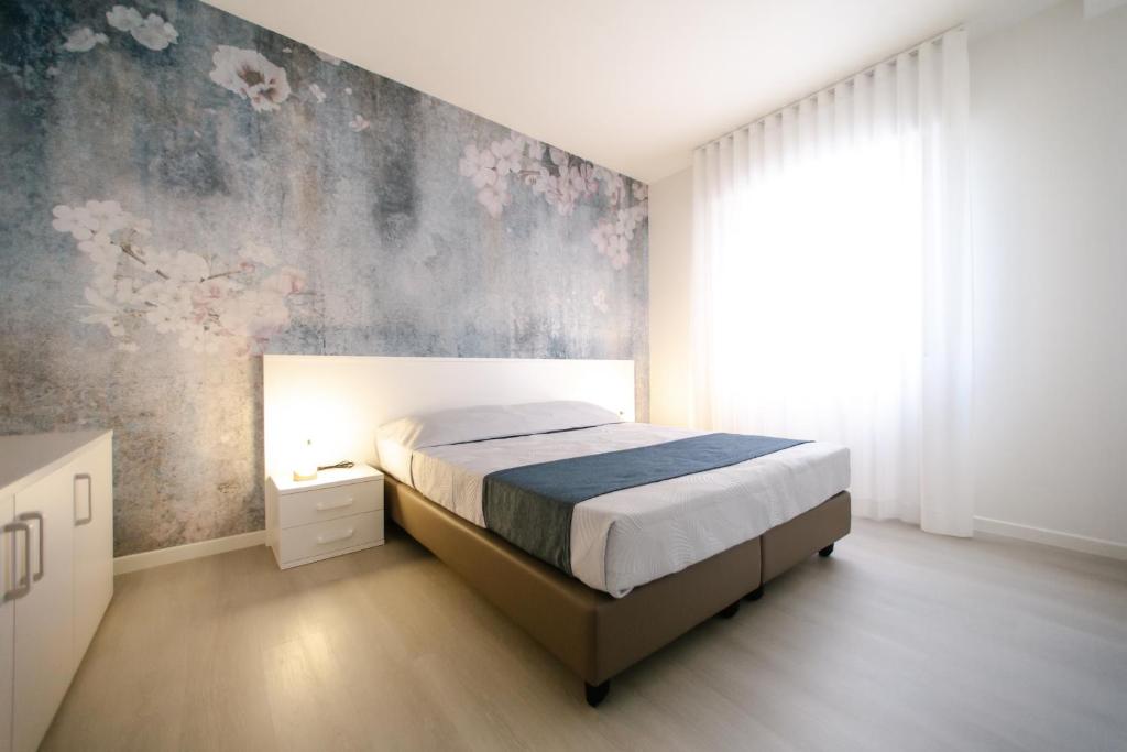 um quarto com uma cama e um mural de parede em MAR60 Apartments em Caorle