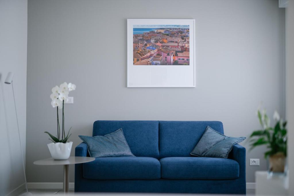 a blue couch in a living room with a picture at MAR60 Apartments in Caorle