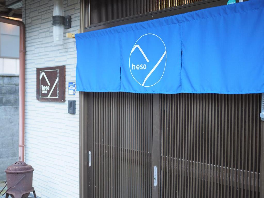 a blue sign on a door of a building at 四国旅行のHUB拠点 古民家ゲストハウス heso camp in Miyoshi