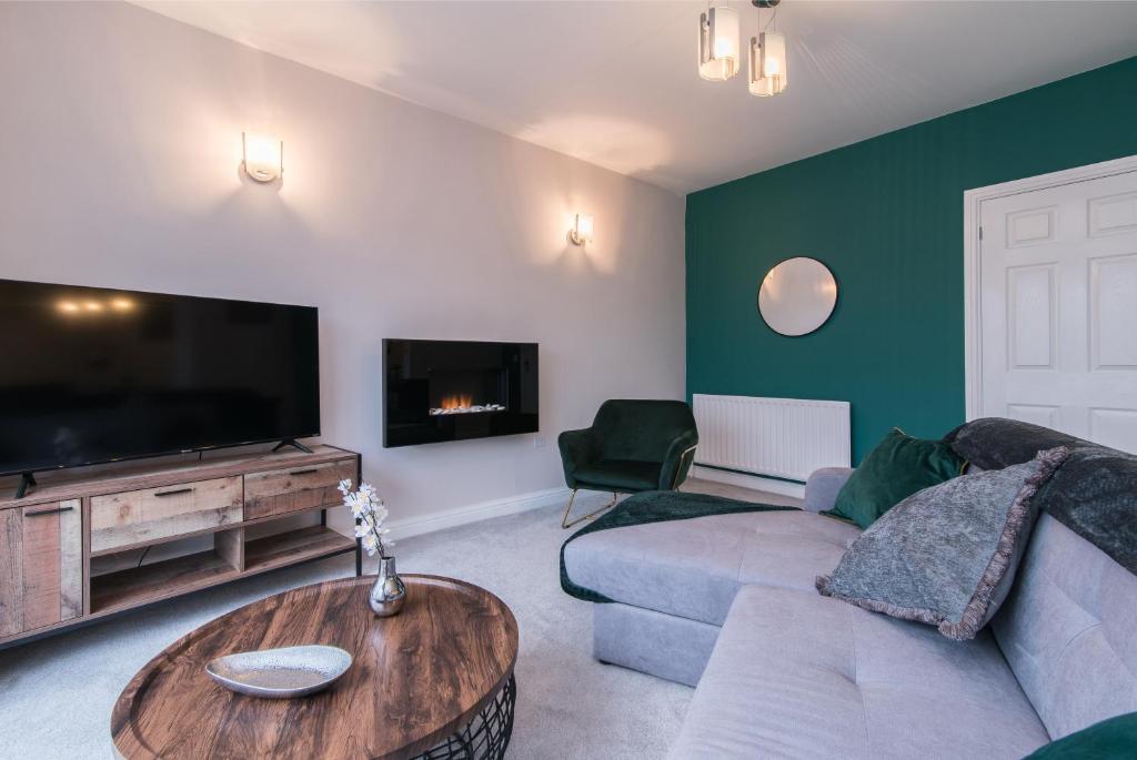 a living room with a couch and a tv at Immaculate 3 Bed House - Stunning Balcony Views in Matlock