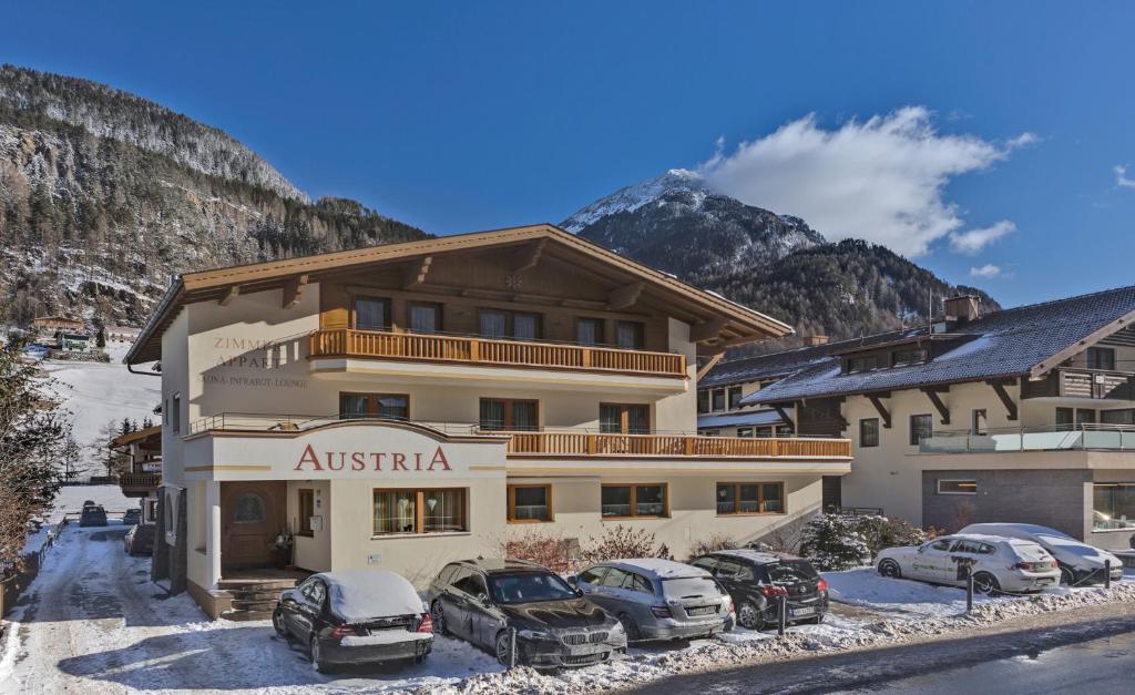 a apartment building with cars parked in front of it at Ferienhaus Austria in Sölden