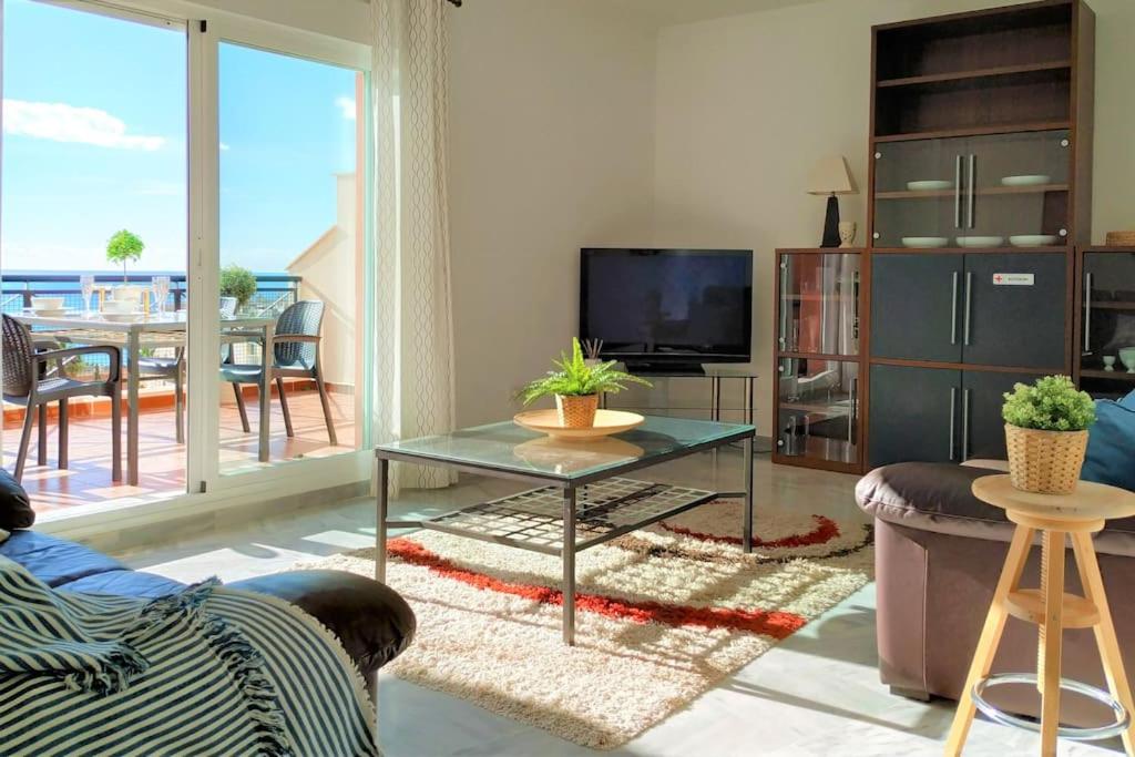 salon z kanapą, stołem i telewizorem w obiekcie Brisa Quebrada Beach, 2 Bed, Sea Views, Pool w mieście Benalmádena