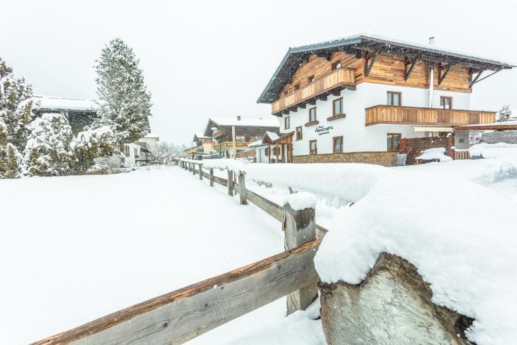 a snow covered fence in front of a house at Haus Alexandra in Werfenweng