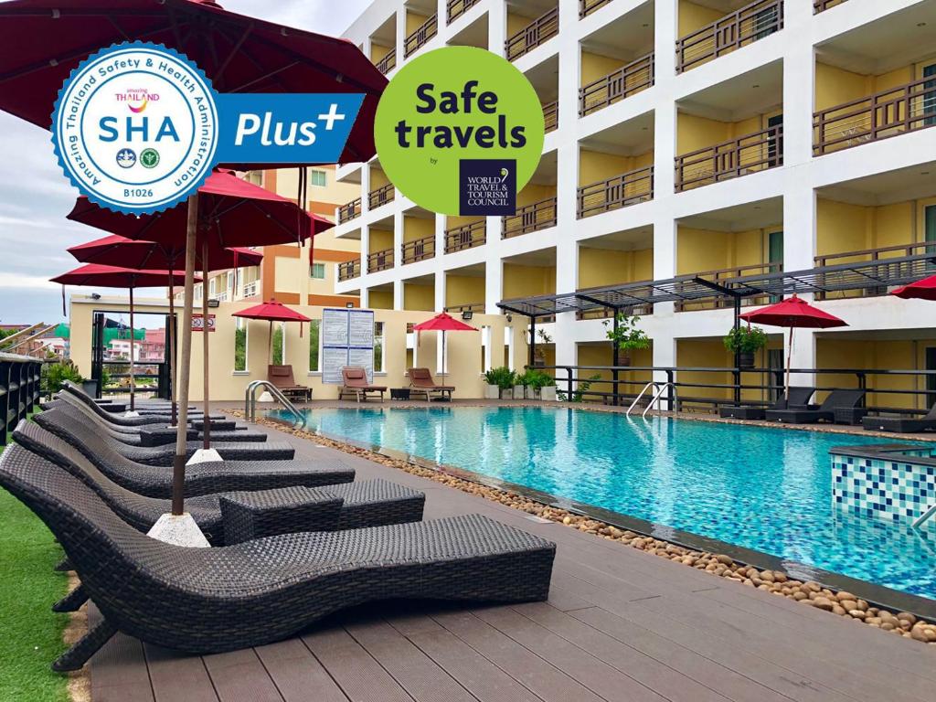 a hotel with a swimming pool with chairs and umbrellas at Golden Sea Pattaya - SHA Extra Plus in Pattaya Central