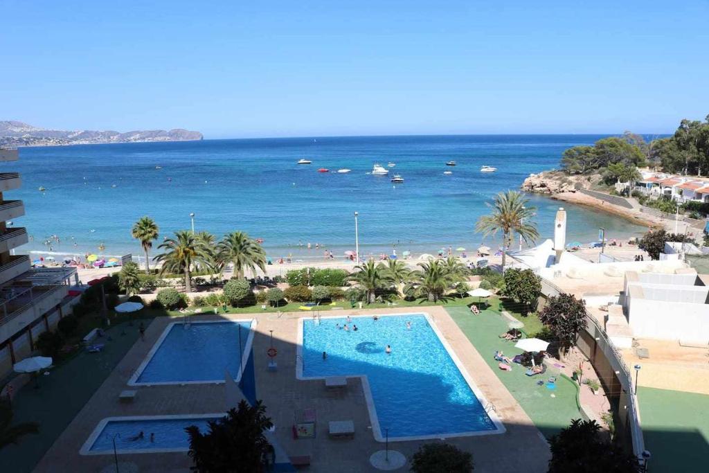 Blick auf ein Resort mit Pool und Strand in der Unterkunft apartamento 46A VORA 2 dormitorio in Calpe