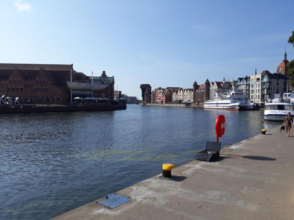 vista su un fiume con edifici e barche di Apartament Maja 2 pokoje stare miasto Gdańsk parking w cenie a Danzica
