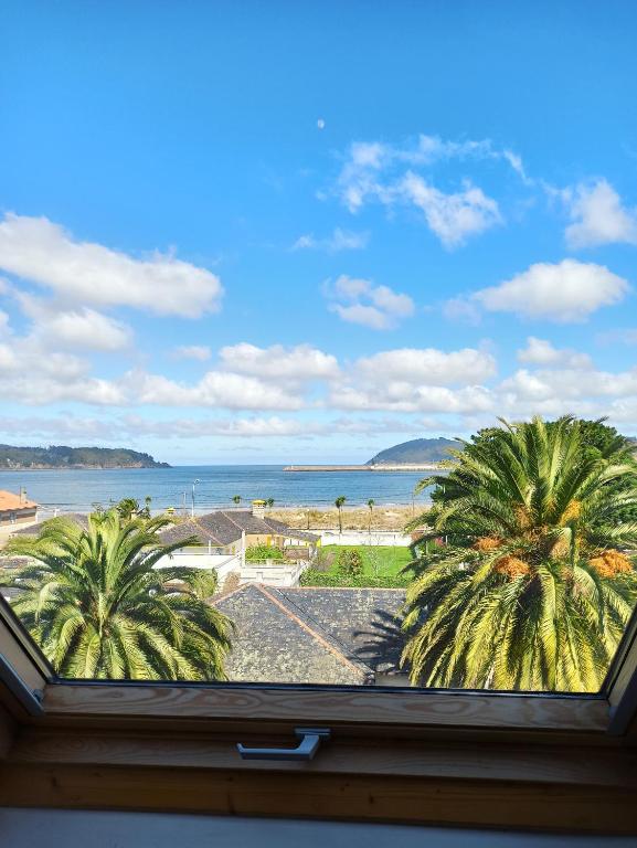 a view of the beach from a window at Ático Sobre el Mar in Viveiro